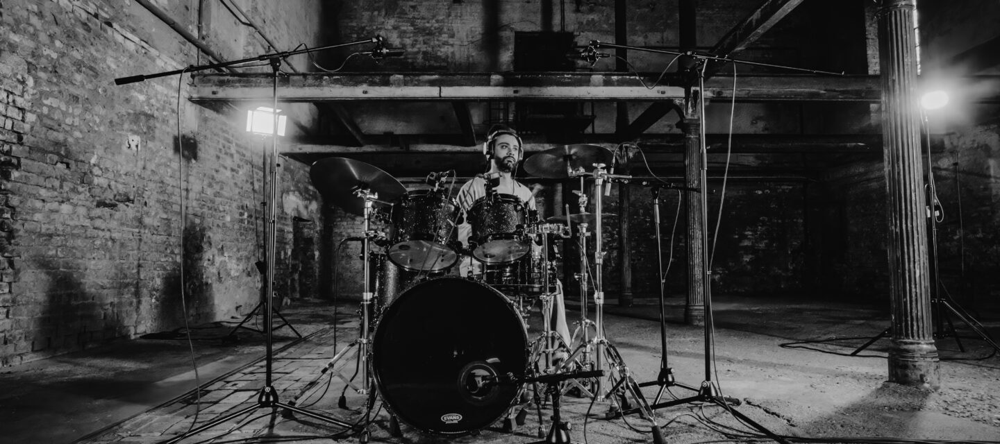 A drummer using the Austrian Audio DMK1 Drum Mic Kit and OC-B6 Kick Mic
